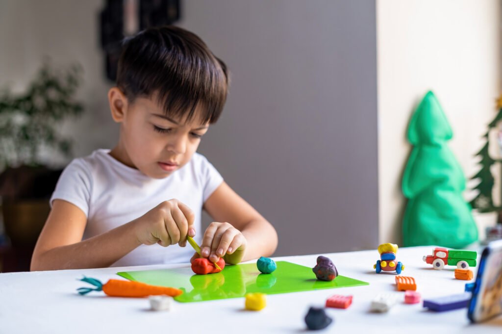 Small boy playing with plasticine